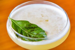 Upclose view of an alcoholic beverage offered at Shingletown with a mint leaf on top