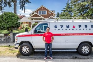 Portrait of an employee standing in front of a Synapse Construction Van