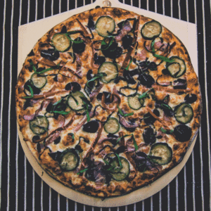 Top down view of a freshly made vegetarian pizza at Zaw on a pizza peele