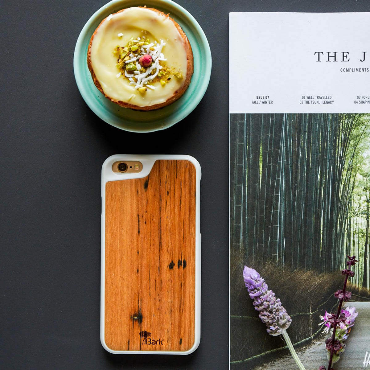 Cellphone with iBark wood cover on table with teacup and book