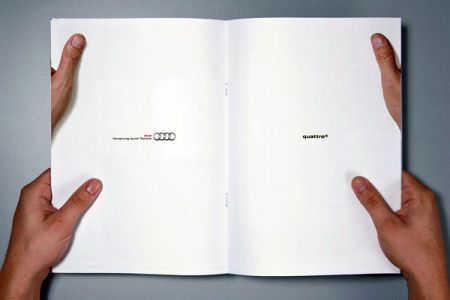 Photo of a man holding a magazine open to a white page of thumbs holding that same page inception style
