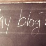 Man's hand writing "why blog?"