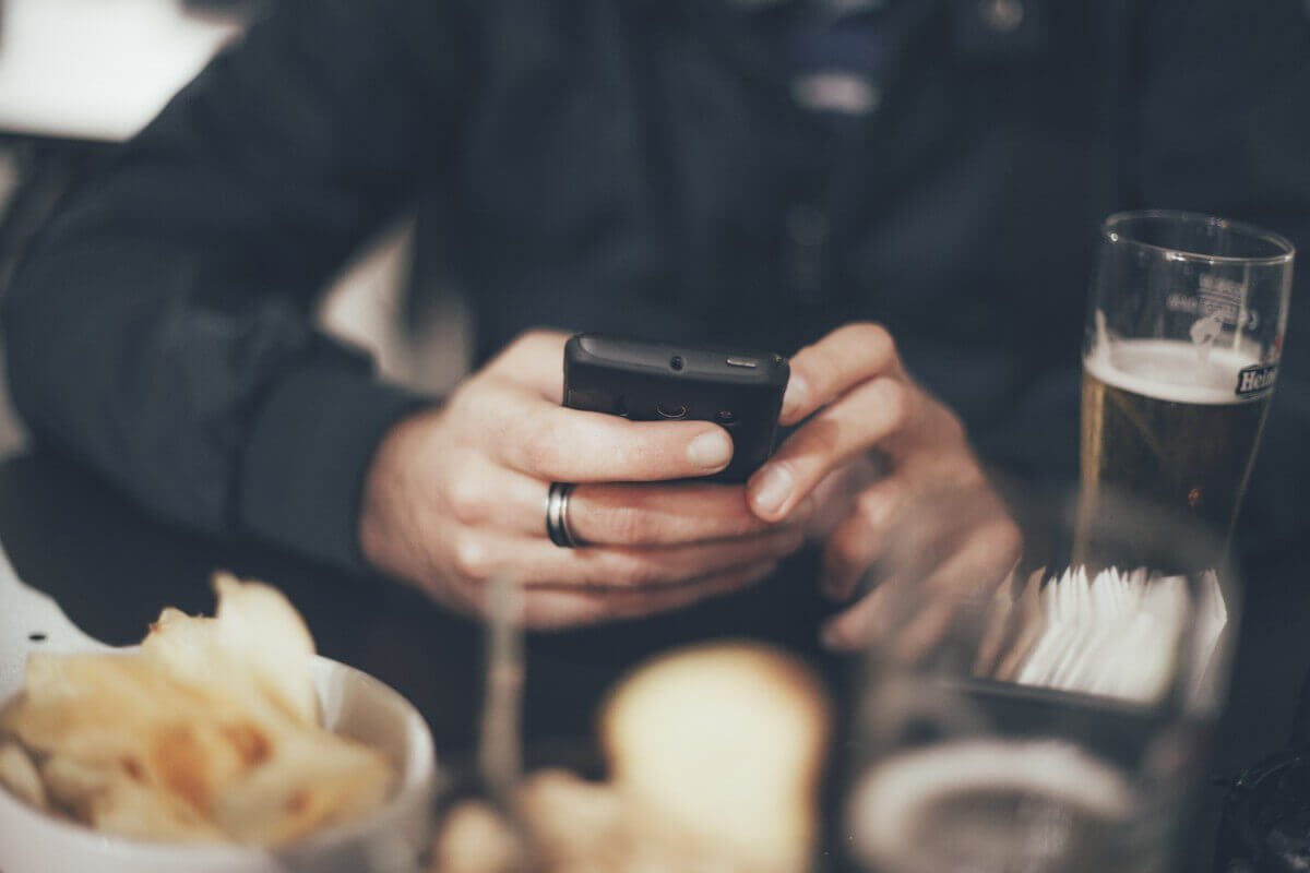 Closeup of someone using their phone on a restaurant table