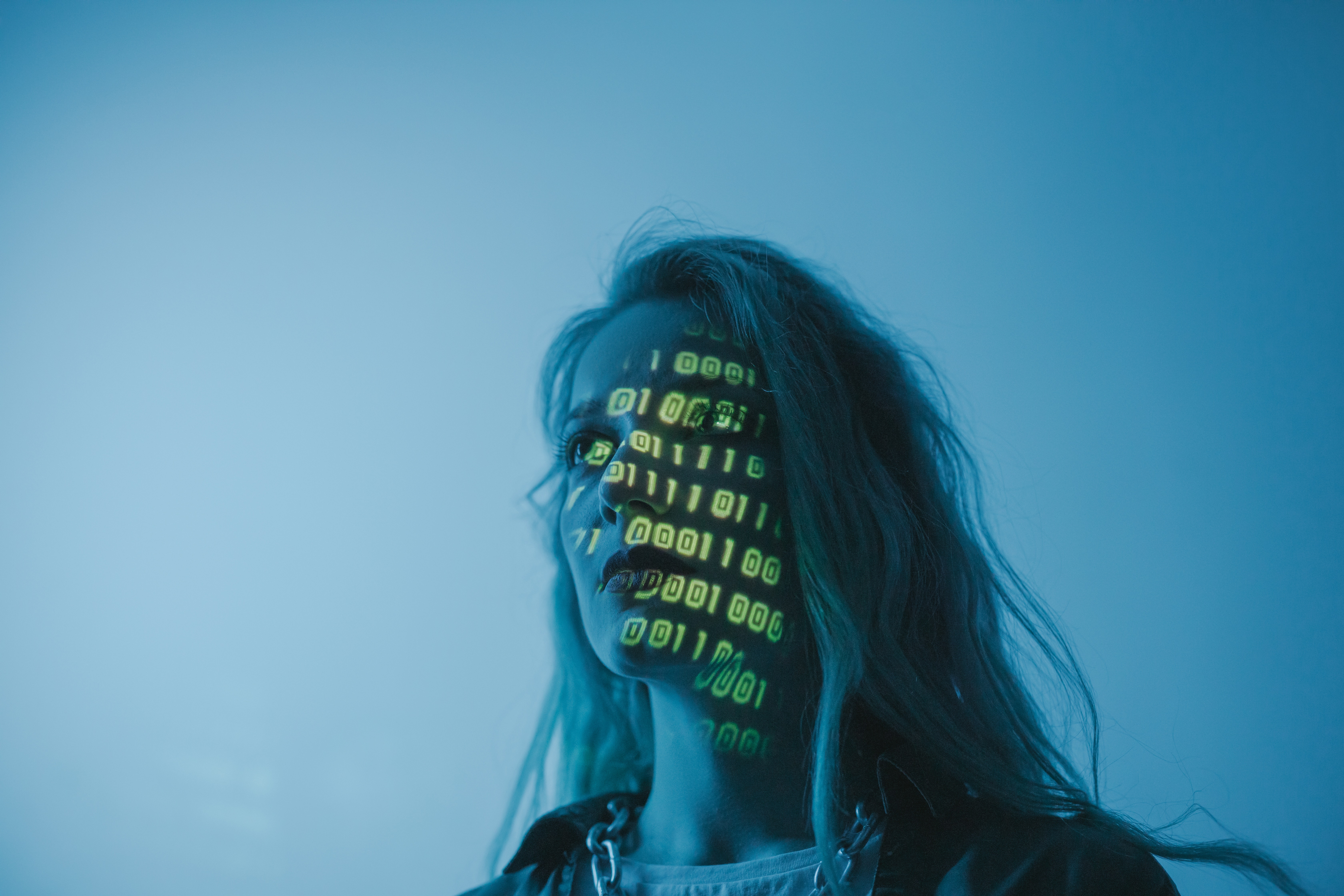 woman in blue light with neon numbers projected across her face
